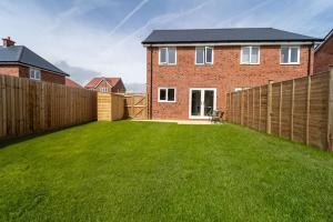 a yard with a fence and a house at Huge Weekly & Monthly Savings - Free Parking - Wi-Fi & Netflix in Gloucester