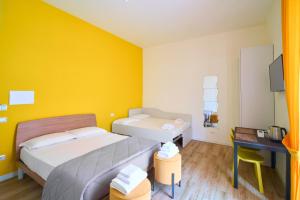 1 Schlafzimmer mit 2 Betten, einem Schreibtisch und einem TV in der Unterkunft Toto e Peppino luxury rooms in Neapel