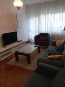 ein Wohnzimmer mit einem Sofa und einem TV in der Unterkunft Pisovistalegre in Vilagarcia de Arousa