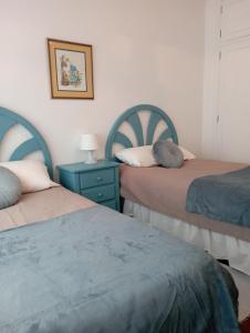 a bedroom with two beds and a blue nightstand at Pisovistalegre in Vilagarcia de Arousa