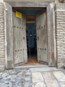 uma entrada para um edifício com duas portas de madeira em Hotel Chorminor Old Premium Est-Since 2003 Mekhtar anbar str131 em Bukhara