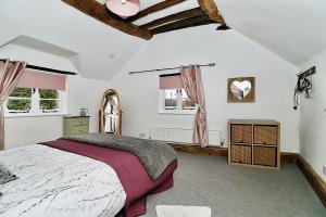a bedroom with a large bed and two windows at Milk & Honey Cottage 2 Bed Ironbridge Retreat in Broseley