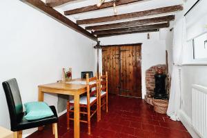 una sala da pranzo con tavolo e sedie in legno di Milk & Honey Cottage 2 Bed Ironbridge Retreat a Broseley