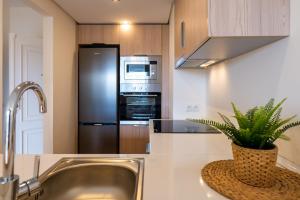 a kitchen with a sink and a stainless steel refrigerator at golf y playa in Benalmádena