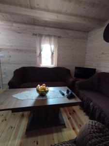 a living room with a table with a bowl of fruit on it at Brvnara Katun in Žabljak