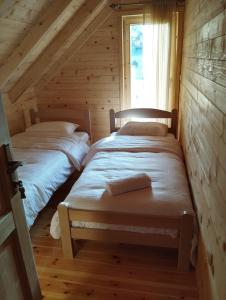 two beds in a room in a log cabin at Brvnara Katun in Žabljak