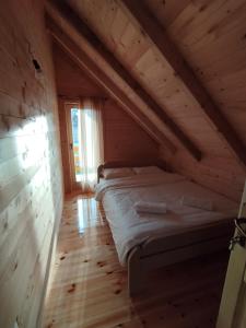 a bedroom with a bed in a wooden attic at Brvnara Katun in Žabljak