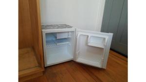 a small white refrigerator with its door open at Hospedagem 154 Colonial in Gramado +36 photos