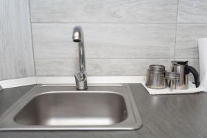 a kitchen sink with a faucet and two cups at Norbert 6 in Arad