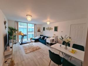 - un salon avec un canapé bleu et une table dans l'établissement Cozy Haven Flat, à Milton Keynes