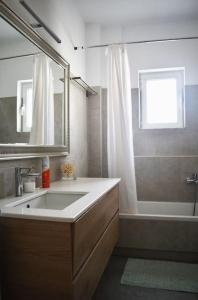 a bathroom with a sink and a tub and a mirror at Giorgos apartment in Ioannina