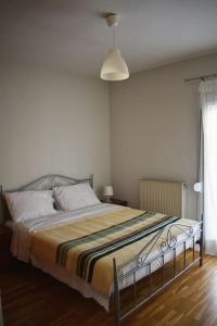a bedroom with a large bed with a striped blanket at Giorgos apartment in Ioannina