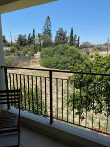 a balcony with a view of a field and trees at Kosher Tersefanou Larnaca in Larnaca