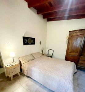 1 dormitorio con 1 cama y puerta de madera en Lunas de Spilimbergo en Córdoba