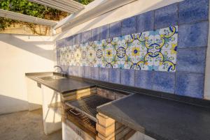 eine Küche mit blauen und weißen Fliesen an der Wand in der Unterkunft Terrazza Incanto in Cefalú