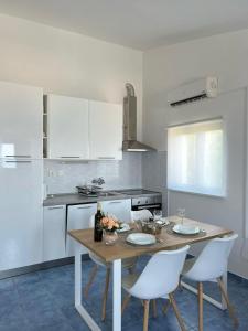 a kitchen with a wooden table and white cabinets at Apartments Ema in Sali