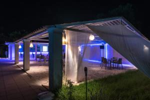 a covered patio with a table and chairs at night at Euphoria ComplexB in Kavos