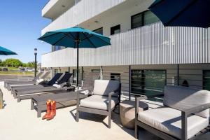 Un grupo de sillas y sombrillas frente a un edificio. en Stylish downtown condo w/ pool & parking, en Nashville