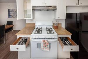 a white stove top oven in a kitchen at LA Paradise: Spacious 3BR Gem with Sleek Interiors in Los Angeles
