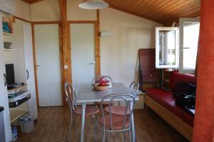 a small dining room with a table and chairs at AGDE chalet sénérité piscine clim 6 PL in Agde