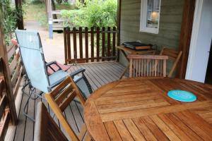 a wooden deck with a table and chairs on a porch at AGDE chalet sénérité piscine clim 6 PL in Agde