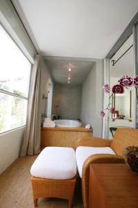 baño con bañera, mesa y sofá en Casa Morada, en Islamorada