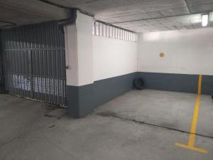 un garage vide avec un mur blanc et vert dans l'établissement Piso con piscina próximo a Plaza de España, à Vigo