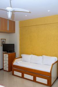 Cette chambre dispose d'un lit et d'un mur jaune. dans l'établissement * Inacreditável Apartamento a 100m da praia! *, à Rio de Janeiro