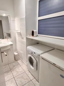 a white bathroom with a washing machine in it at The Sunrise, Spacious, fully equipped, 2 parkings, 8p, tramway 1,2,4 in Montpellier +8 photos