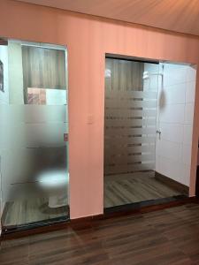 a bathroom with two glass doors in a room at Pousada ACRÓPOLE in Belém