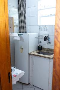 La cuisine blanche est équipée d'un réfrigérateur et d'un évier. dans l'établissement * Inacreditável Apartamento a 100m da praia! *, à Rio de Janeiro