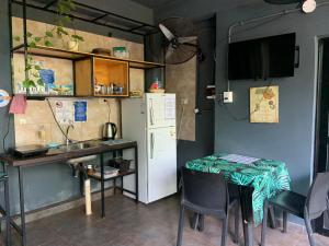 kuchnia ze stołem i białą lodówką w obiekcie Ambar House Apart w mieście Puerto Iguazú