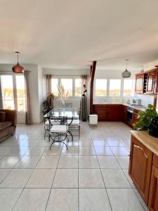 a large kitchen and living room with a table and chairs at The Sunrise, Spacious, fully equipped, 2 parkings, 8p, tramway 1,2,4 in Montpellier