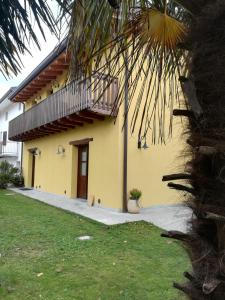 Una casa amarilla con una escalera en el lateral. en Agriturismo "La di Buiat, en Cividale del Friuli