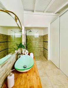 een badkamer met een groene wastafel en een bad bij Grande Villa de standing vue mer, piscine 3ilets in Les Trois-Îlets