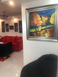 a living room with a red couch and a painting on the wall at Luxury Room SC in San Cristóbal
