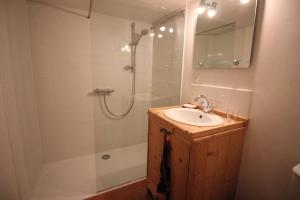 y baño con lavabo y ducha con espejo. en Atmospheric, original stone chalet in Meribel, en Les Allues
