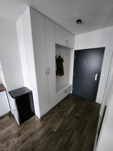 a room with white cabinets and a black door at Apartman - Centrum in Bratislava