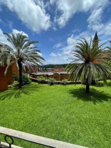 2 palmiers dans un parc avec un banc dans l'établissement Tyla Villa in Port Chambly, à Terre Rouge