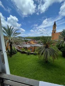a view of a church and palm trees from a balcony at Tyla Villa in Port Chambly in Terre Rouge