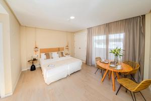 a bedroom with a bed and a table and chairs at Vive Costa Azul in Benalmádena
