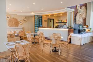 a restaurant with tables and chairs and a bar at Vive Costa Azul in Benalmádena