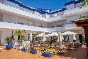 a courtyard with tables and chairs and umbrellas at Vive Costa Azul in Benalmádena