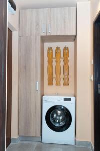 a laundry room with a washing machine and wooden cabinets at Robert room 18 in Arad