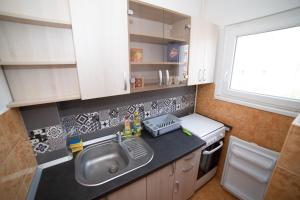 a small kitchen with a sink and a window at Robert room 18 in Arad