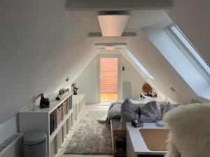 a attic room with a couch and a window at Ferienhaus Neuseenland in Großzössen