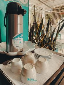 a table with plates and cups and a coffee maker at Hotel Casa Martina Valledupar in Valledupar +28 photos