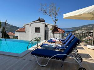 Un grupo de tumbonas azules junto a una piscina. en Villa Deniz, en Kalkan