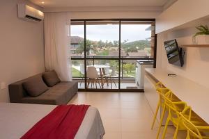 um quarto com uma cama, um sofá e uma varanda em Hosts BR - Estúdio Eco Resort Praia dos Carneiros em Tamandaré