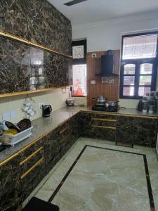 a kitchen with marble counter tops and a window at Luxe Ganga view Villa with Terrace Seating (Vacaow) in Rishīkesh